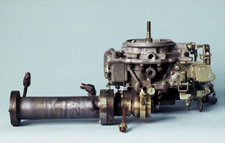 Microplasmatronic fuel converter (foreground) and conventional carburetor (background)