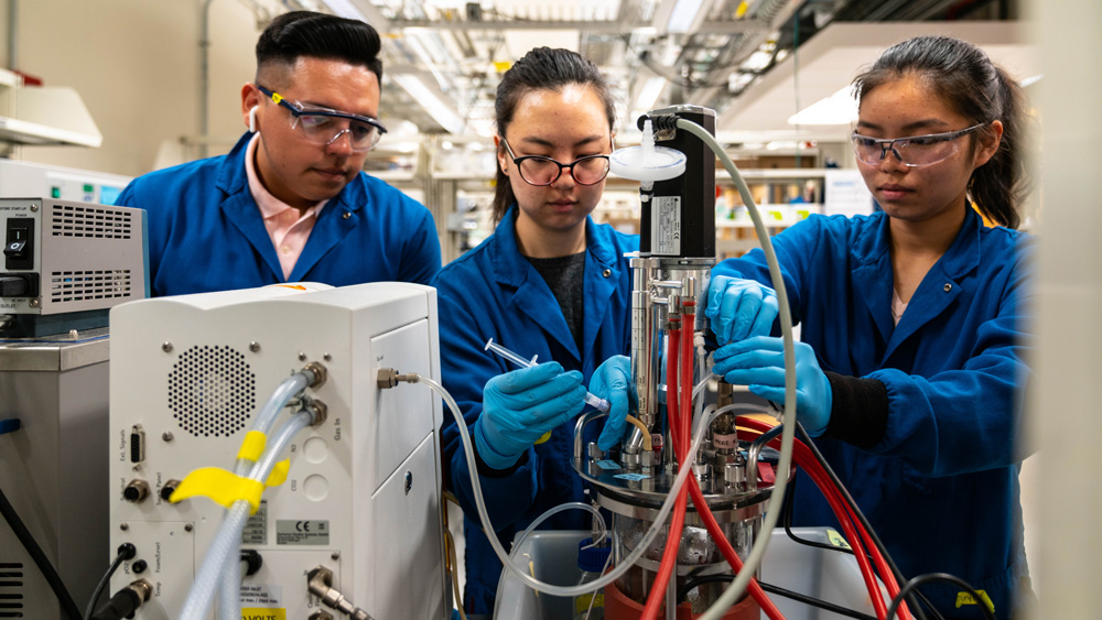 Three MIT students working in a lab