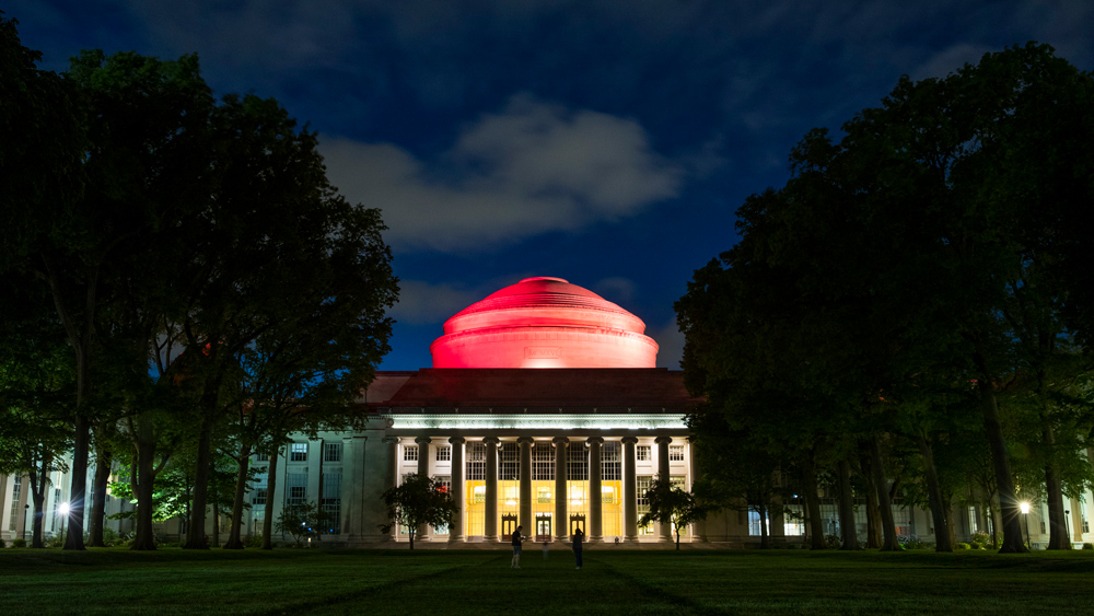 MIT's Great Dome bathed in red light the evening before 2020's online Commencement ceremony