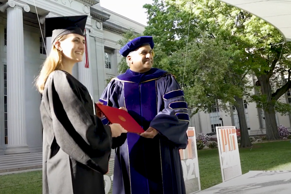 An MIT female graduate posing for a photo with the Dean of the School of Engineering 