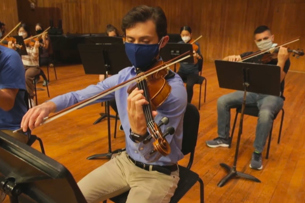 Students playing violin in orchestra