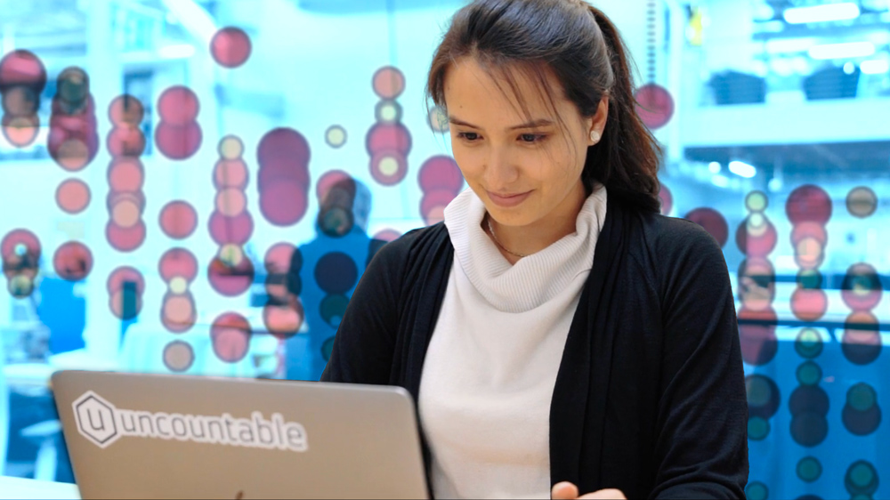 Woman working on laptop with data in background