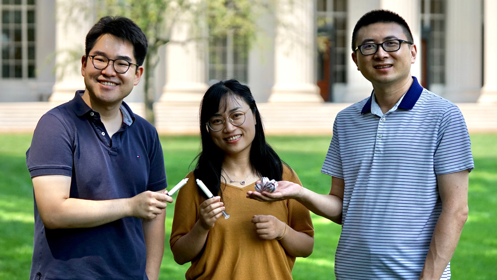 3 researchers in Killian Court holding new device