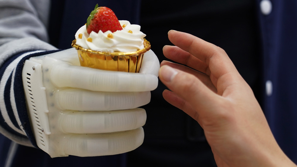 An MIT-developed inflatable robotic hand holding a cupcake