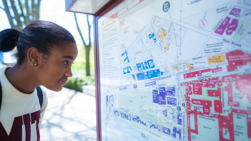an MIT student looking at a campus map