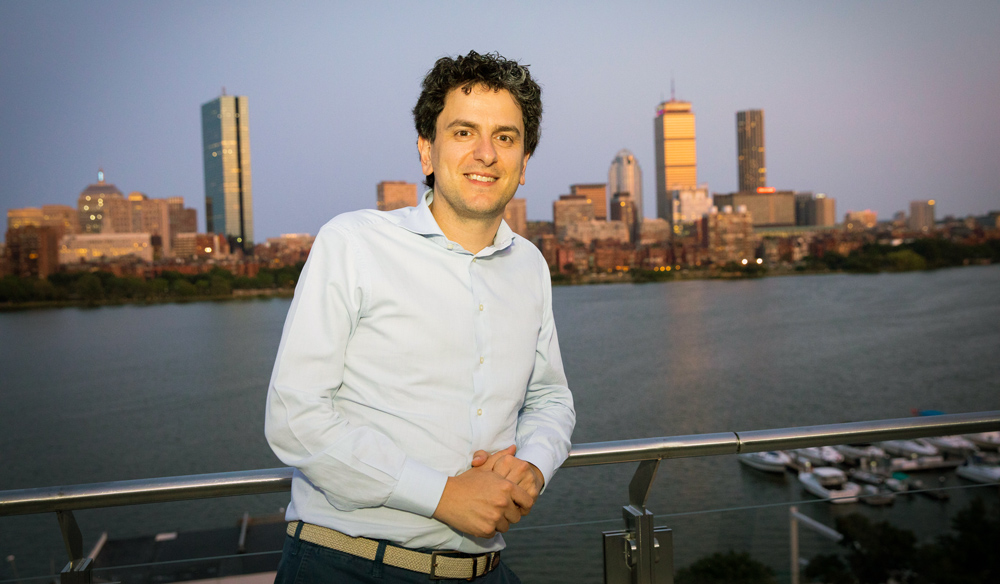 Photo of Nikos Trichakis with Charles River and Boston skyline in background