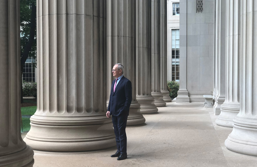 L. Rafael Reif standing among the columns overlooking Killian Court