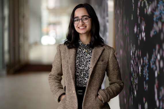 Isha Mehrotra wearing a brown blazer and smiling 