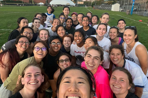 The MIT Women's Ultimate Frisbee Team outside on a field
