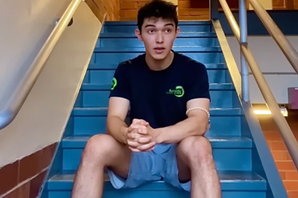 Reuben Fuchs sitting in a stairwell and singing