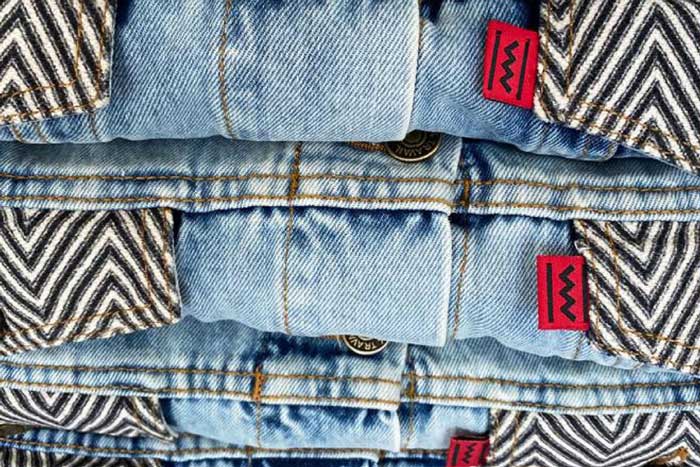 Closeup of jeans and striped fabric with Congo Clothing Company's red and black label.