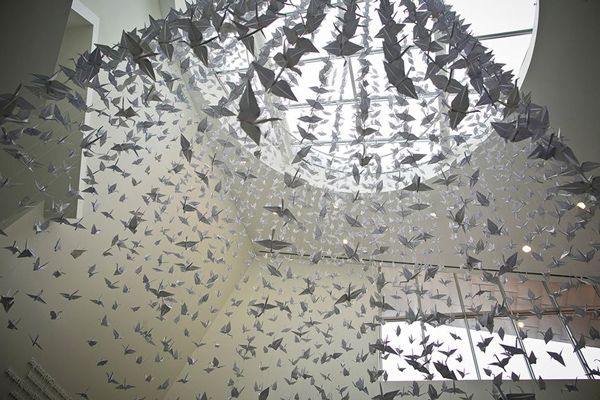 A thousand paper cranes hanging from a skylight in MIT's Stata Center
