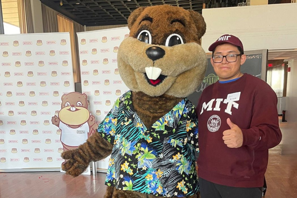 Tim the Beaver standing with a student wearing an MIT sweatshirt