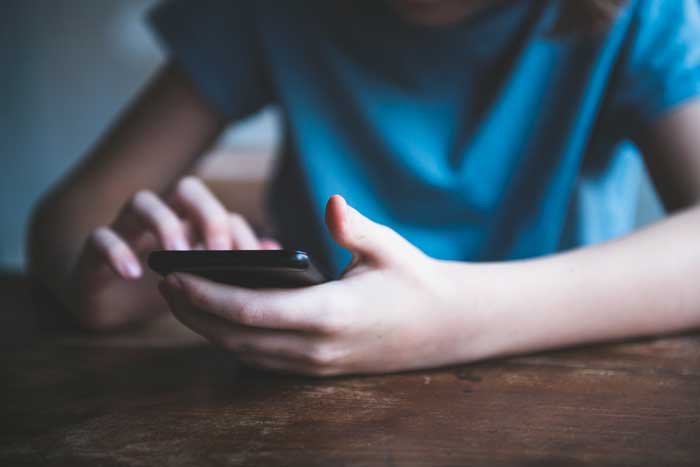 Young person's hands using a cell phone