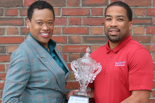 two people holding a crystal trophy