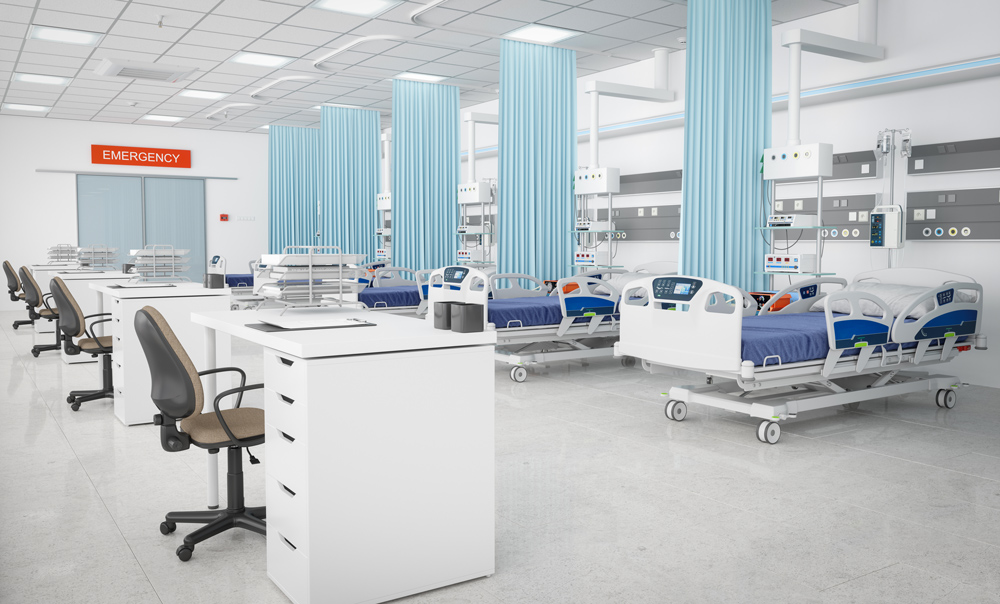 an empty emergency room with four sets of hospital beds and reception desks.