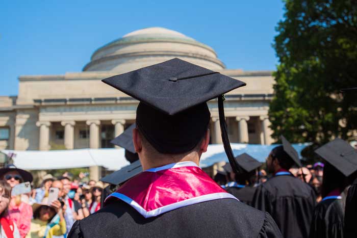 A graduate student looks at the Great Dome while walking in Killian Court