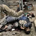 A US Marine pushes dead Iraqi fighters in the center of Fallujah, Iraq, Friday, Nov. 12, 2004. (AP Photo/Anja Niedringhaus)
