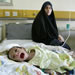 Iraqi woman Rahab Ali al-Musawi, 18, looks on while her three-month-old boy Ali Mohammed reacts while getting treatment for diarrhea in the General Teaching Hospital for Children in Baghdad, Iraq, Thursday, June 3, 2004. More than a year of U.S. occupation has not significantly improved health care in Iraq. (AP Photo/Anja Niedringhaus)