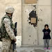 An Iraqi girl covers her ears as a Marine of the 1st Division, 3/5, patrols the center of  the heavily guarded town of Fallujah, Iraq, Saturday, Feb. 05, 2005. (AP Photo/Anja Niedringhaus)