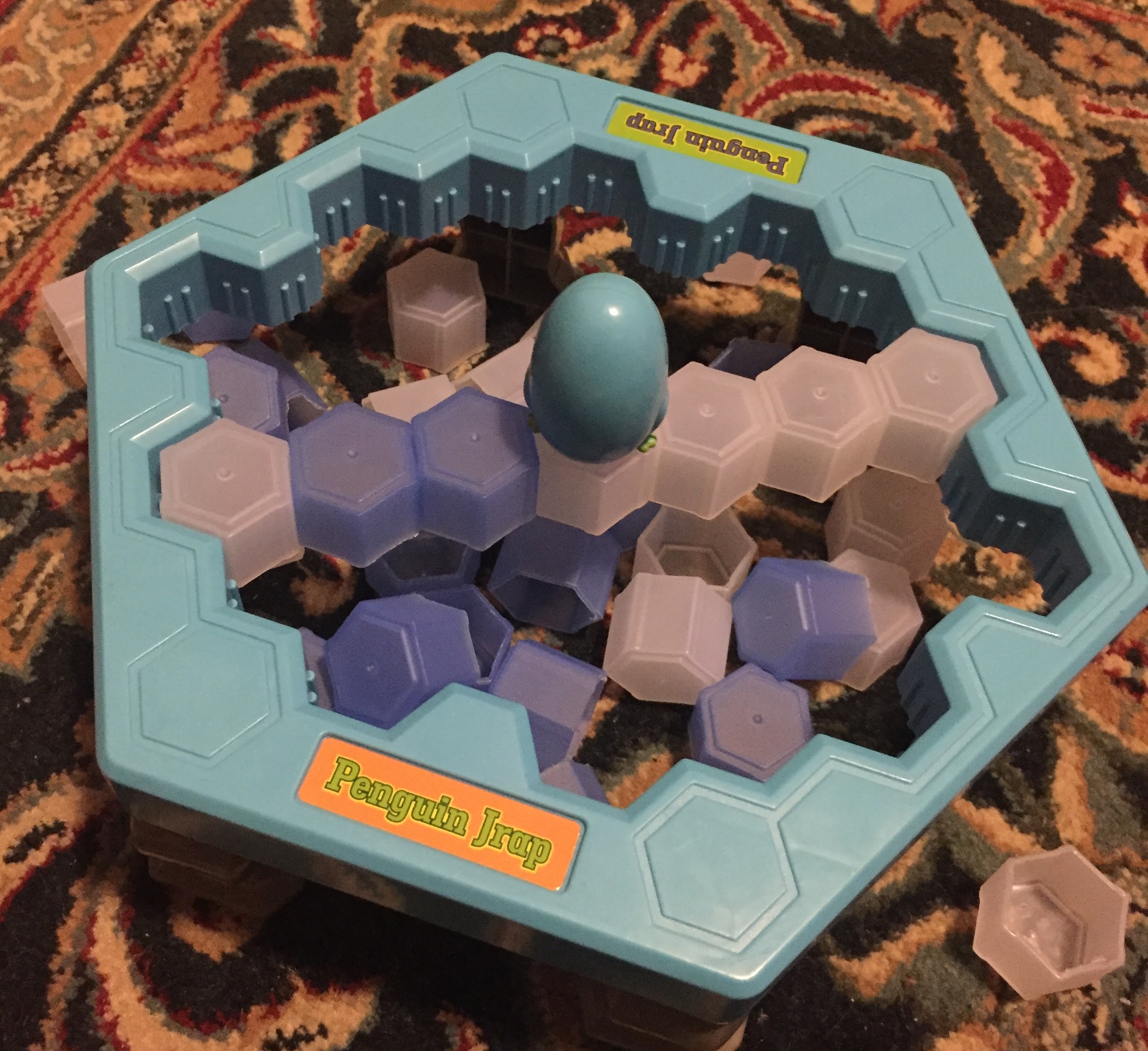 A penguin figure perched precariously on a line of hexagonal ice blocks as part of the game Penguin Jrap