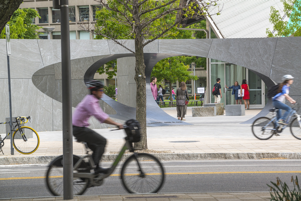 A person on a bicycle rides past the Collier Memorial.
