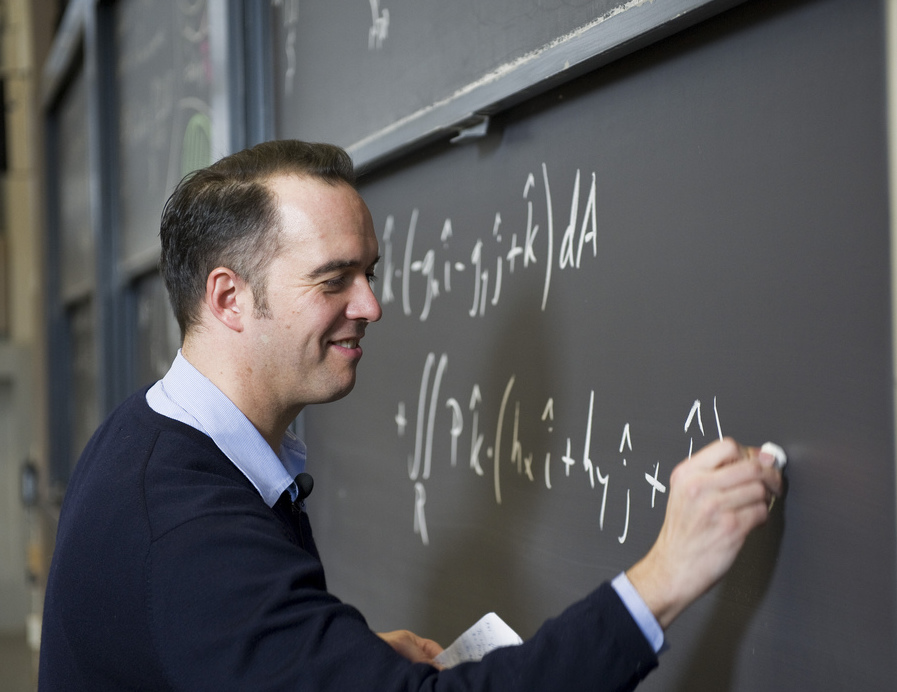Professor writing an equation on a chalkboard