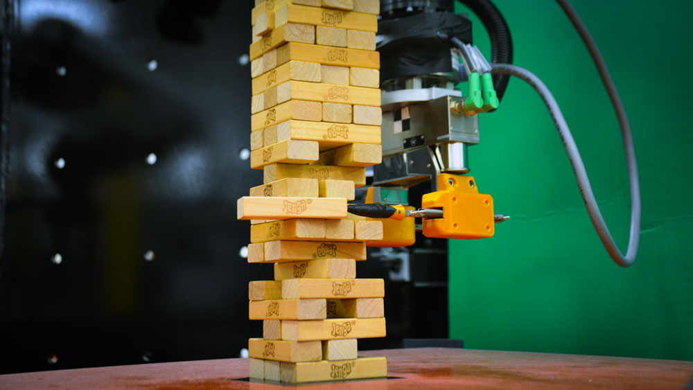 A photograph of a robot playing Jenga