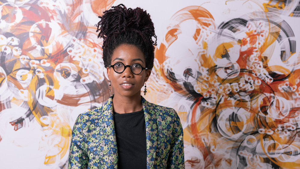 An image of Brooke Wages in front of a mural