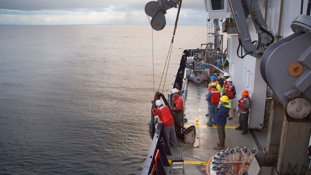 An image of people deploying a discharge hose and studied sediment plumes from the deep sea