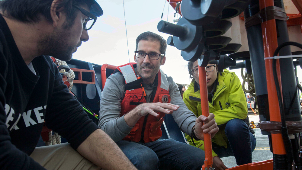 An image of Professor Thomas Peacock and Cindy Dayang Wang examine a CTD cage 