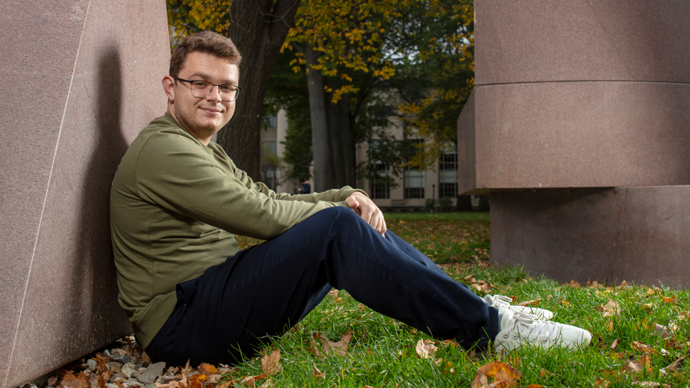 Barotta leaning against sculpture in Killian Court, by M Scott Brauer