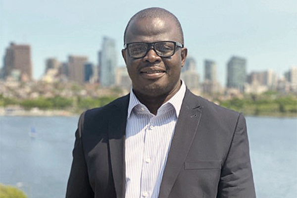 Carl Kwaku Dey MBA ’21 outside with cityscape in background