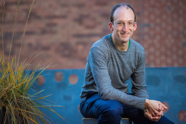 Mike Short sitting in front of a brick wall