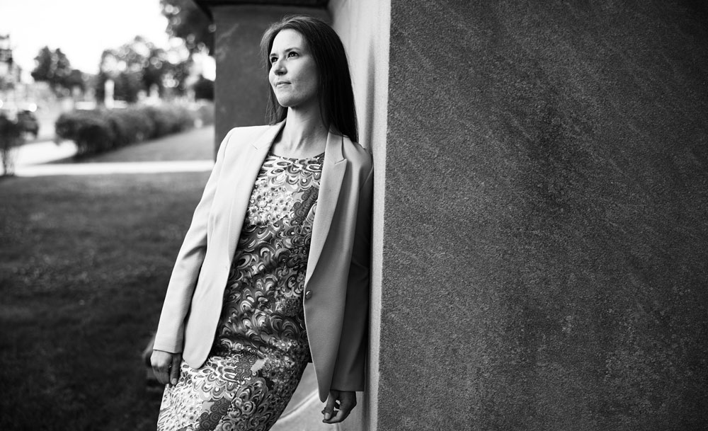 monochrome photo of Kristy Johnson leaning against a wall