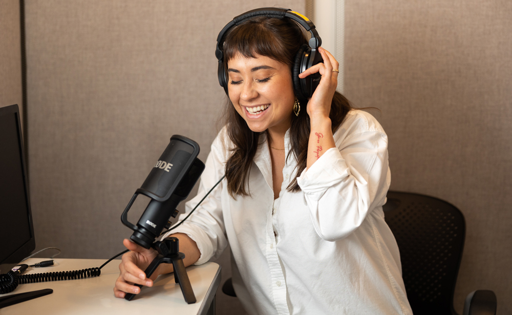 Jessica Chomik-Morales at the microphone wearing headphones