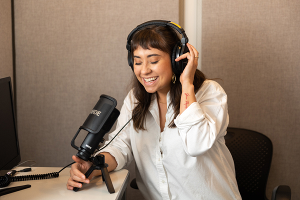 Jessica Chomik-Morales at the microphone wearing headphones