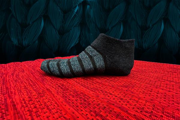 a knit sock on top of a red knit mat