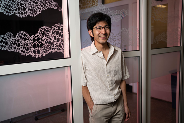 Photo of Pablo Leon in MIT doorway, with windows with decals
