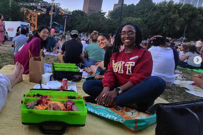 Nia and a group of students outside having a picnic at a performance
