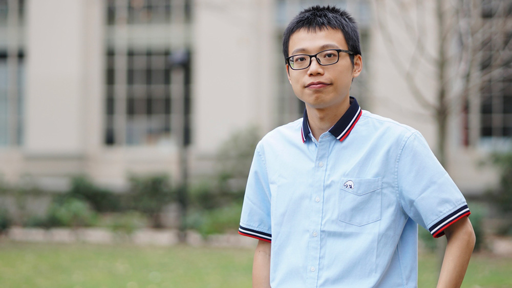 Hao Zhang stands outside on MIT campus