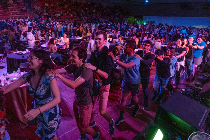 Students, staff, faculty, and their guests formed a conga line in the Johnson Ice Rink with purple lights. 