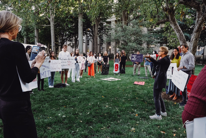 Professor Linda Griffith, right, addresses about 30 people holding signs at an event on Killian Court. 