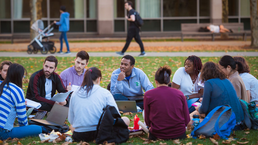 Group of students in a circle having an outdoor discussion