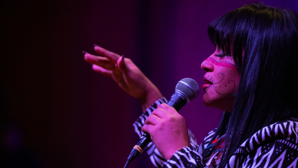 Djuena Tikuna singing into a microphone