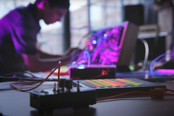 a student sitting at a purple electric magenta colored board that is lit up