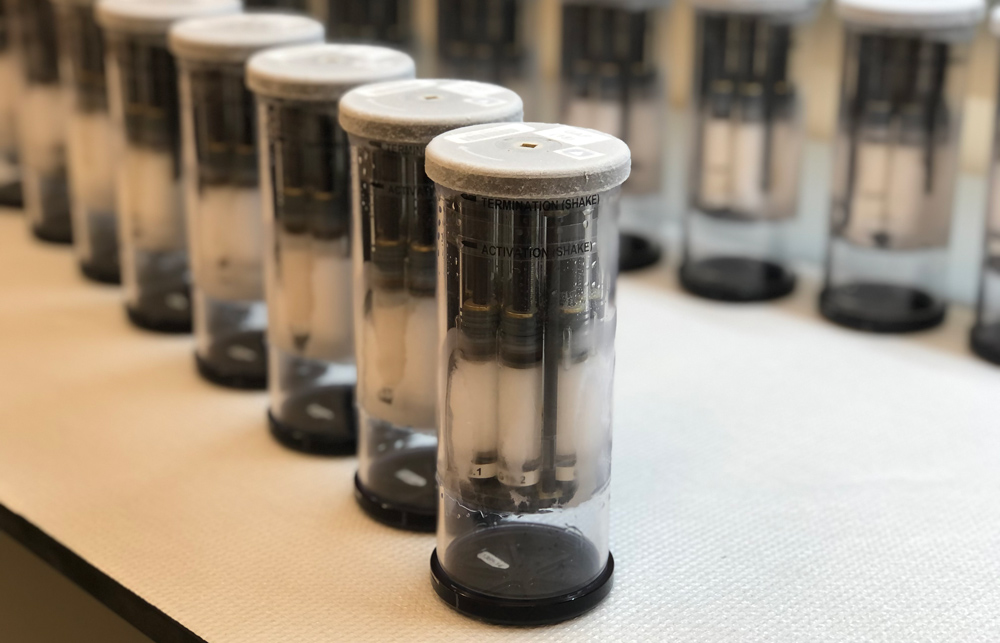 2 rows of canisters, and each canister has smaller canisters with white fluid inside them.