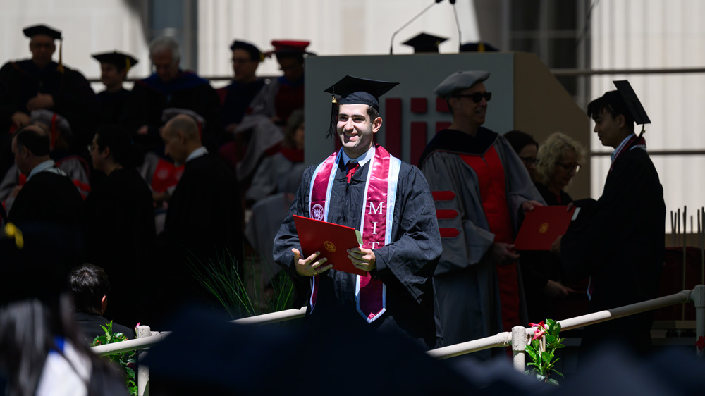 a graduate smiles after receiving his diploma