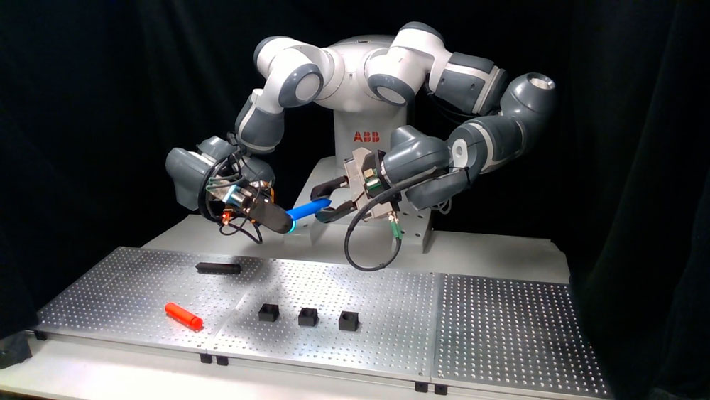 A robotic arm picks objects from the table in a lab test