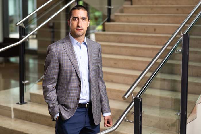 Andrew Sutherland stands in Sloan next to a stairway